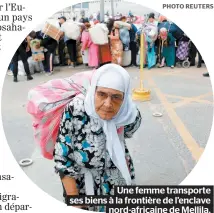  ?? PHOTO REUTERS ?? Une femme transporte ses biens à la frontière de l’enclave nord-africaine de Mellila.