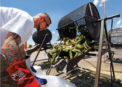  ?? GABRIELA CAMPOS/NEW MEXICAN FILE PHOTO ?? Matt Flores helps out the family business, Los Chile Bros, outside Big Lots in 2017. Colorado Gov. Jared Polis, in promoting his state’s chile crop, slammed New Mexico’s signature product as ‘inferior.’