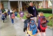  ?? AP PHOTO BY MICHAEL MELIA ?? In this Nov. 6 photo, campus monitor Hector Garcia greets students as they got off the bus at the start of the school day at West Elementary School in New Canaan, Conn.