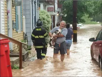  ?? EVAN BRANDT — MEDIANEWS GROUP ?? Pete Santiago rescues his dog from floodwater­s on Walnut Street Thursday evening.