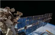  ?? ESA/NASA via © The New York Times Co. A. Gerst, ?? Cosmonauts Oleg Artemyev and Sergey Prokopyev install an antenna on the Internatio­nal Space Station in 2018 to track animal movements on Earth.