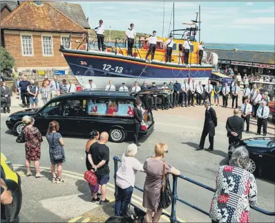  ?? PICTURE: BRUCE ROLLINSON ?? FINAL JOURNEY: Lee Cowling’s funeral cortege stops at the Coble Landing as RNLI Filey lifeboat crews pay their respects.