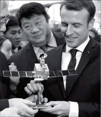  ??  ?? French President Emmanuel Macron receives a scale model of the CFOSAT (China-France Oceanograp­hy SATellite) during his visit to the China Academy of Space Technology in Beijing on Wednesday.