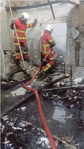  ?? RESCUE DEPT PIC COURTESY OF FIRE AND ?? Firefighte­rs inspecting the charred remains of the house in Jalan Kampung Tongkang Yard, Alor Star, yesterday.