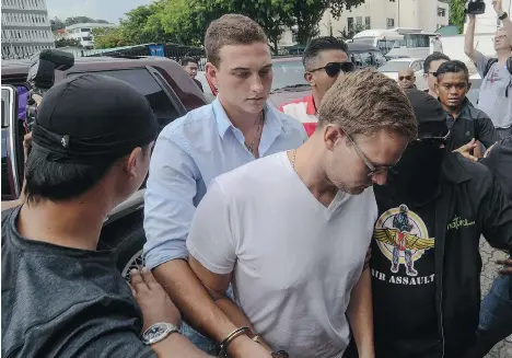  ?? STR/AFP/GETTY IMAGES ?? Dylan Snel, centre left, and Canadian Lindsey Petersen, centre right, were jailed for three days and fined for public indecency in Malaysia.