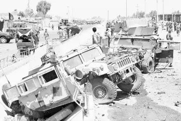 ??  ?? Afghan National Army (ANA) soldiers inspecting damaged army vehicles after a suicide attack in Lashkar Gah, Helmand province, Afghanista­n. — Reuters photo