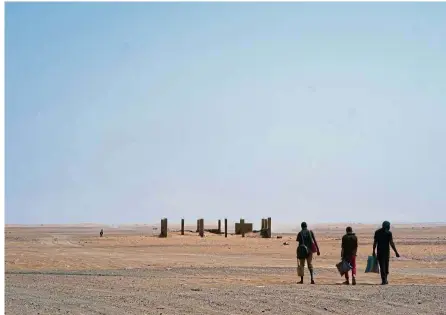  ?? — AP ?? No man’s land: Three men trudging miserably across some of the world’s most unforgivin­g terrain in the blistering sun after crossing the Assamaka border post.