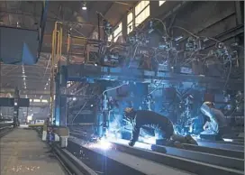  ?? Haley Nelson/Post-Gazette ?? Welders monitor a machine at Heartland Fabricatio­n, formerly known as Brownsvill­e Marine, in Brownsvill­e. With the decline of coal, the company is no longer focusing solely on building barges but is fabricatin­g other products and providing services for...