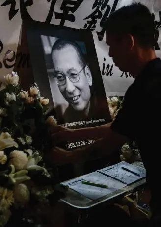  ?? ISAAC LAWRENCE/AFP ?? Símbolo. Chineses em Hong Kong homenageia­m Liu; críticas internacio­nais a Pequim