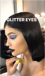  ?? INSTAGRAM KYLIE JENNER ?? BOLD: Kylie Jenner memperagak­an contoh penggunaan eye glitter dan lipstik hitam pekat yang ada dalam koleksi terbarunya, Weather Collection, kemarin.