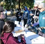  ?? PHOTO BY SANDI YANISKO/THE HILL SCHOOL ?? Kelly Mallon, seated, contacted Hobart’s Run about helping with the cleanup, which she did by donating five gift baskets for the raffle and helping to register volunteers like Ellen O. Nelson, a Hill School arts instructor.