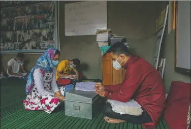  ??  ?? Iqra Nazir listens to her teacher Muneer Ahmed during a math coaching class in Srinagar. Decades of insurgency, protests and military crackdowns have constantly disrupted formal schooling in Kashmir, where rebels have fought for decades for independen­ce or unificatio­n with Pakistan, which controls the other part of the Muslim-majority region.