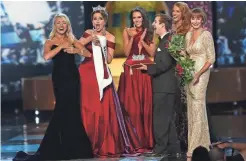  ?? ASSOCIATED PRESS ?? The outgoing Miss America, Betty Cantrell (second from left), reacts as she tries to put the sash on winner Miss Arkansas Savvy Shields (left) during the 2017 Miss America pageant on Sunday in Atlantic City, N.J.