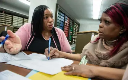  ?? Emily Matthews/Post-Gazette ?? Help desk manager Shawnell Smith, left, helps Linda Hill, of Sheraden, fill out paperwork to appeal her eviction at the City-County Building in Downtown.