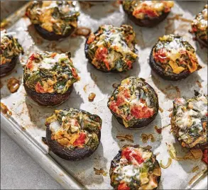  ?? TOM MCCORKLE/WASHINGTON POST ?? Spinach and Cheese Stuffed Mushrooms are bursting with juiciness and will shatter any notions that vegetables can’t be buzzworthy party fare.