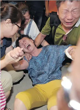  ?? PORNCHAI KITTIWONGS­AKUL/ AFP/ GETTY IMAGES ?? Relatives of a Chinese tourist killed in a bombing outside a religious shrine grieve after identifyin­g the body in Bangkok on Tuesday. Police said tourists from China, Hong Kong, Indonesia, Malaysia and Singapore were among those killed in the attack.