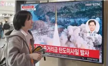  ?? — AFP ?? A woman walks past a television screen showing a news broadcast with file footage of a North Korean missile test, at a railway station in Seoul.