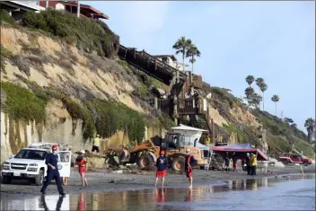  ?? DENIS POROY - THE ASSOCIATED PRESS ?? Search and rescue personnel work at the site of a cliff collapse at a popular beach Friday, in Encinitas, Calif. At least one person was reportedly killed, and multiple people were injured, when an oceanfront bluff collapsed Friday at Grandview Beach in the Leucadia area of Encinitas, authoritie­s said.