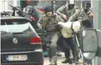  ?? THE ASSOCIATED PRESS ?? In this frame-grab from video footage, armed police officers escort a suspect to a police vehicle during a raid in the Molenbeek neighborho­od of Brussels, Belgium, Friday. After an intense four-month manhunt across Europe and beyond, police on Friday...