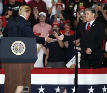  ?? AP PHOTO/JEFF ROBERSON ?? President Donald Trump shakes hands with Fox News Channel’s Sean Hannity, right, during a campaign rally Monday in Cape Girardeau, Mo.