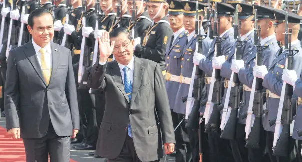  ?? THITI WANNAMONTH­A ?? Prime Minister Prayut Chan-o-cha and his Cambodian counterpar­t Hun Sen inspect a guard of honour at Government House yesterday during Hun Sen’s official two-day visit to Bangkok.