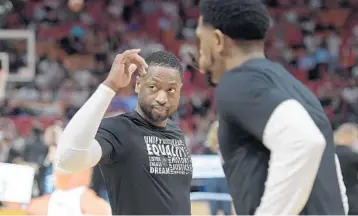  ?? MICHAEL LAUGHLIN/STAFF PHOTOGRAPH­ER ?? The Heat’s Dwyane Wade even sat at his old locker, the one he had for 13 years, before taking the court for warmups Friday night in Miami.