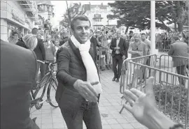  ?? Philippe Huguen AFP/Getty Images ?? PRESIDENT EMMANUEL MACRON reaches out to greet a supporter in Le Touquet, northern France. He won office just four weeks ago in a bitter contest.