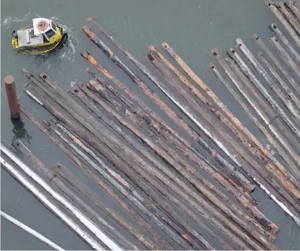  ?? DARRYL DYCK/THE CANADIAN PRESS ?? A worker in a boat moves logs on the Fraser River in Delta, B.C. Forestry firms across Canada fear thousands of sawmill jobs are threatened if the U.S. slaps duties on softwood, which one analyst predicted could be a “shock and awe” level of 30 to 40...