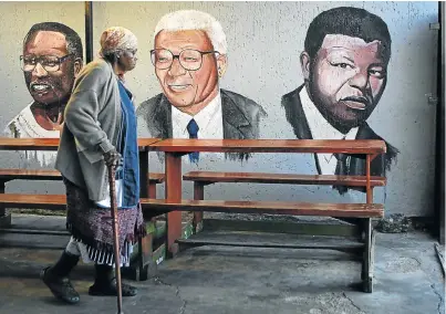  ?? Picture: REUTERS ?? LEGACY BETRAYED: Sarah Kunene, 84, walks past murals of Oliver Tambo, Walter Sisulu and Nelson Mandela, whose moral conduct stands as a reproach to present-day ANC leaders