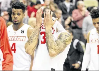  ?? DAVID JABLONSKI / STAFF ?? Dayton’s Kyle Davis covers his face as he leaves the court after Friday’s shocking loss to Davidson in the quarterfin­als of the Atlantic 10 Tournament in Pittsburgh.