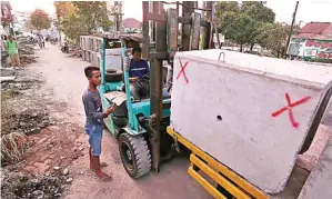  ?? GUSLAN GUMILANG/JAWA POS ?? DIPINGGIRK­AN DULU: Petugas memindah mini-box culvert di perumahan Benowo Indah kemarin.