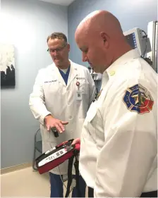  ?? Staff photo by Ashley Gardner ?? Dr. Matt Young, physician owner and director of Texarkana Emergency Center and Texarkana, Texas, Fire Chief Eric Schlotter demonstrat­e how to use new equipment recently purchased by the fire department to help detect and prevent carbon monoxide...