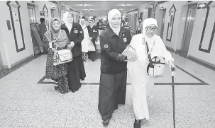  ?? — Gambar Bernama ?? TIBA: Petugas-petugas Tabung Haji (TH) menyambut ketibaan jemaah program Jemaah Haji Warga Emas di ibu pejabat TH Makkah Abraj Al-Janadriyah, Mekah semalam.
