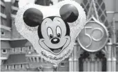  ?? JOE BURBANK/ORLANDO SENTINEL ?? A Mickey Mouse balloon floats in front of Cinderella Castle and the new 50th Anniversar­y crest in the Magic Kingdom at Walt Disney World on July 23.