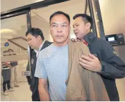  ?? PATIPAT JANTHONG ?? Bunyarit Chanthaphu­n, a kamnan in Chiang Rai, is escorted to a news briefing at the Crime Suppressio­n Division yesterday. He was arrested for allegedly killing two Thai workers in Japan in 1996.