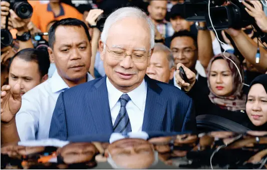  ?? Photo: AFP ?? Former Malaysian prime minister Najib Razak leaves the courthouse in Kuala Lumpur on Wednesday after being charged in court. Malaysian ex-leader Najib Razak and Arul Kanda, the former 1Malaysia Developmen­t Berhad fund head, were charged on Wednesday with altering an audit of the state fund at the center of a scandal which helped topple the last government.