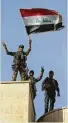  ?? Associated Press ?? Iraqi forces raise a flag Friday after retaking Bartella, outside Mosul.