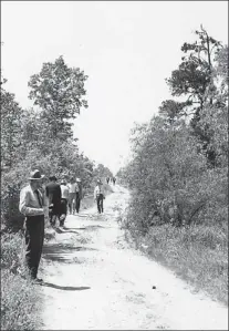  ?? Photos courtesy of Tillman Johnson family ?? Left: Law officers search along North Park Road in April 1946 for clues in the Phantom Killer’s third attack. Paul Martin, 16, and Betty Jo Booker, 15, were killed early Sunday morning, April 14, 1946, in wooded areas north and west of Spring Lake Park.