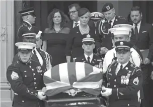  ?? SUSAN WALSH/ASSOCIATED PRESS ?? The casket of Republican Sen. John McCain of Arizona is carried Saturday from Washington National Cathedral after a memorial service, as Cindy McCain is escorted by her son, Jimmy McCain, and other family members.