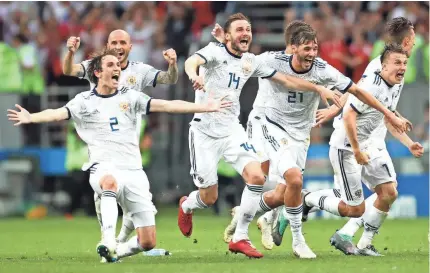  ?? PA IMAGES/SIPA USA VIA USA TODAY SPORTS ?? Russia’s Mario Fernandes, Vladimir Granat, Aleksandr Yerokhin, Aleksandr Golovin, Fyodor Kudryashov, Roman Zobnin, Ilya Kutepov and Fyodor Smolov celebrate defeating Spain on Sunday.