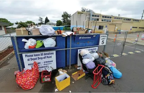  ?? PHOTO: KEVIN FARMER ?? WHAT A WASTE: The donation bins at the St Vincent de Paul store on the corner of Ruthven and Long Sts were left overflowin­g in the wet weather this weekend after residents dumped household goods.