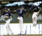  ?? MATT SLOCUM — THE ASSOCIATED PRESS ?? The Brewers’ Lorenzo Cain, Orlando Arcia and Christian Yelich celebrate after Game 1 of the National League Championsh­ip Series Friday in Milwaukee. The Brewers won 6-5 to take a 1-0 lead in the series.