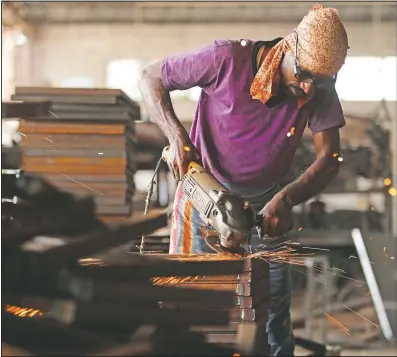  ?? (AP/Channi Anand) ?? An Indian worker prepares steel furniture at a factory on the outskirts of Jammu, India. Millions of distressed Indian manufactur­ers and traders are counting on the eagerly awaited October-December festive season to rescue them from their coronaviru­s catastroph­e.