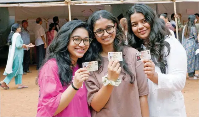  ?? Associated Press ?? ↑
First time voters display their voter card before casting their ballots at a polling station in Mumbai, on Monday.