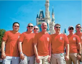  ?? JACOB LANGSTON/ORLANDO SENTINEL the World Tour ?? A group of 9 friends wear their Gay Days 2014 shirts while hanging out in the Magic Kingdom on June 7, 2014. Many who attend Gay Days celebratio­n events at Disney wear red shirts.