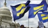  ?? JACQUELYN MARTIN / THE ASSOCIATED PRESS FILE ?? People with the Human Rights Campaign hold up “equality flags” during an event on Capitol Hill in Washington, in support of transgende­r members of the military.