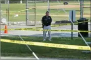  ?? CLIFF OWEN/THE ASSOCIATED PRESS ?? A police office stands watch behind police tape near strewn baseballs on a field in Alexandria, Va., Wednesday, J after a multiple shooting involving House Majority Whip Steve Scalise of La.