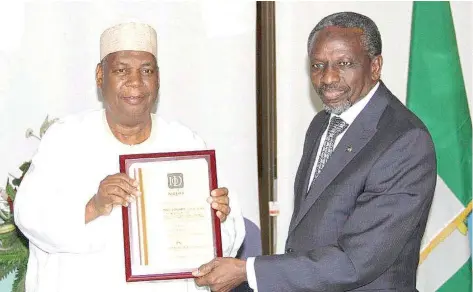  ??  ?? Managing Director and Chief Executive Officer, Nigeria Deposit Insurance Corporatio­n (NDIC), Alhaji Umaru Ibrahim, receiving an award from the President, Institute of Directors (IOD), Alhaji Ahmed Rufai, during a courtesy call on NDIC management at the...