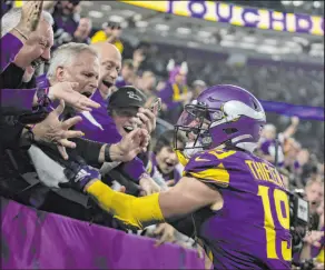  ?? Andy Clayton-king The Associated Press ?? Vikings wide receiver Adam Thielen celebrates with fans behind the end zone after catching the go-ahead touchdown midway through the fourth quarter.