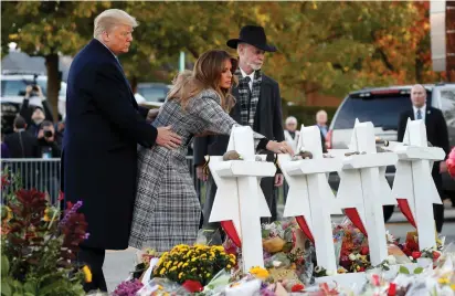  ?? (Kevin Lamarque/Reuters) ?? US PRESIDENT Donald Trump, first lady Melania Trump and Rabbi Jeffrey Myers place stones on a memorial at the Tree of Life Synagogue on Tuesday.